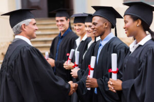 professor shaking hands with graduates