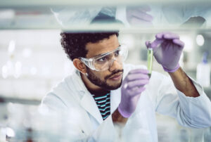 scientist looking at test tube