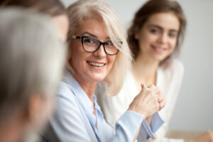 businesswoman listening to team at meeting