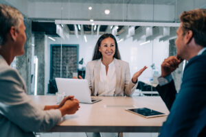 Two businesspeople talking to a woman consultant.